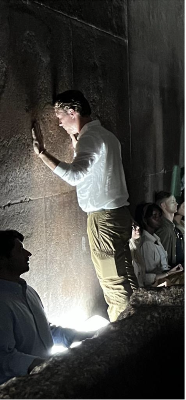 Person exploring dark pyramid passage